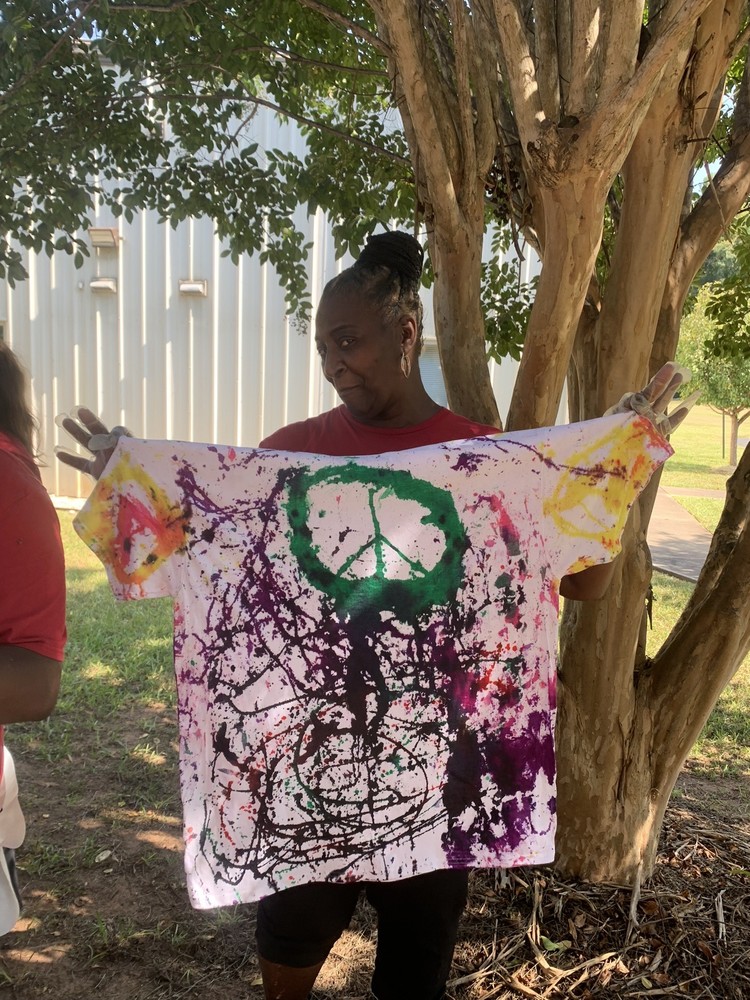 woman holding up tie dyed shirt
