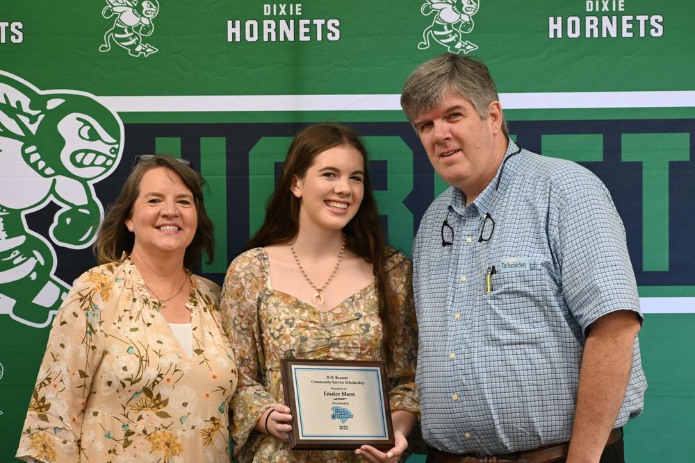 Emallee and her parents holding her plaque
