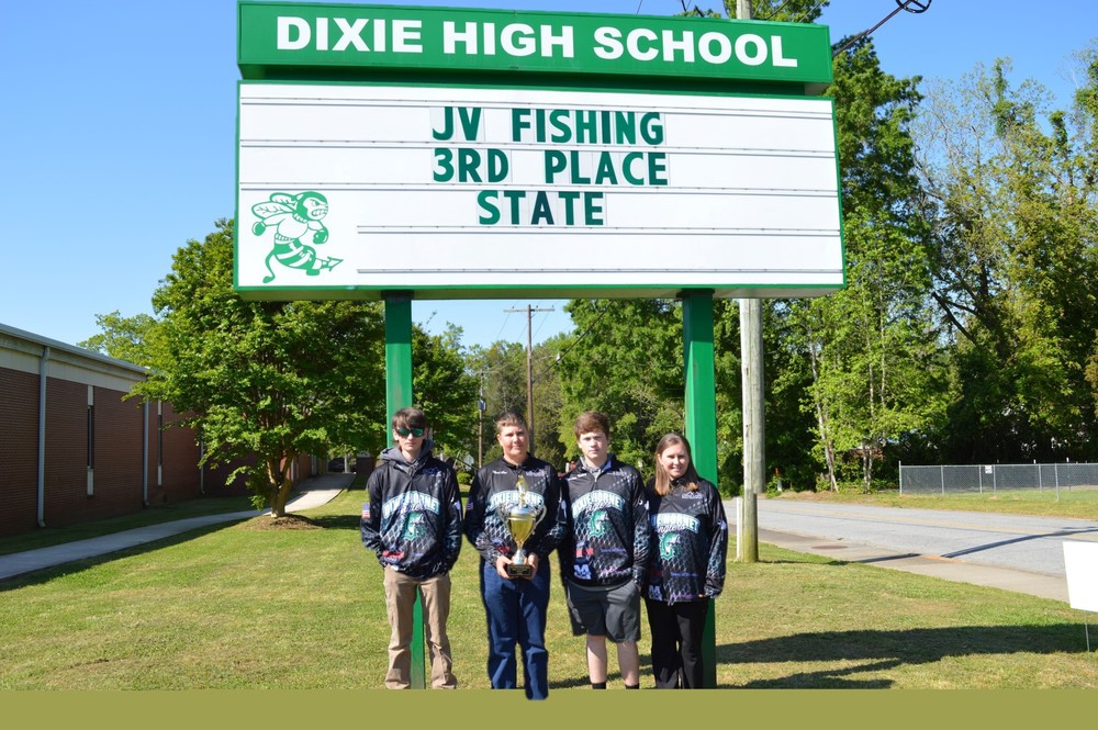 Fishing team holding their trophy under the Dixie sign announcing that they are 3rd in the State. 