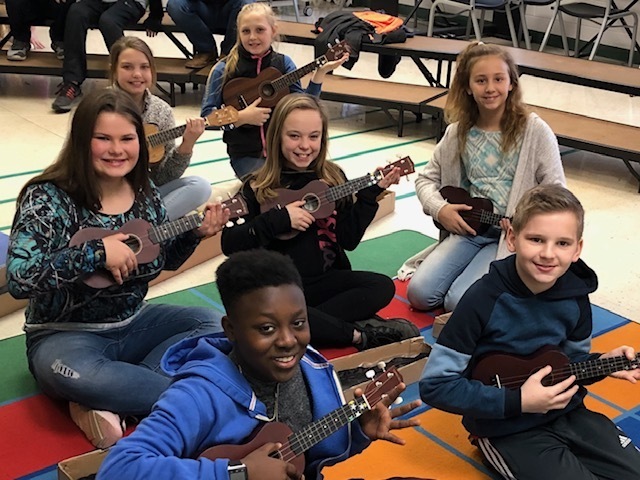 Fifth grade students playing the ukulele
