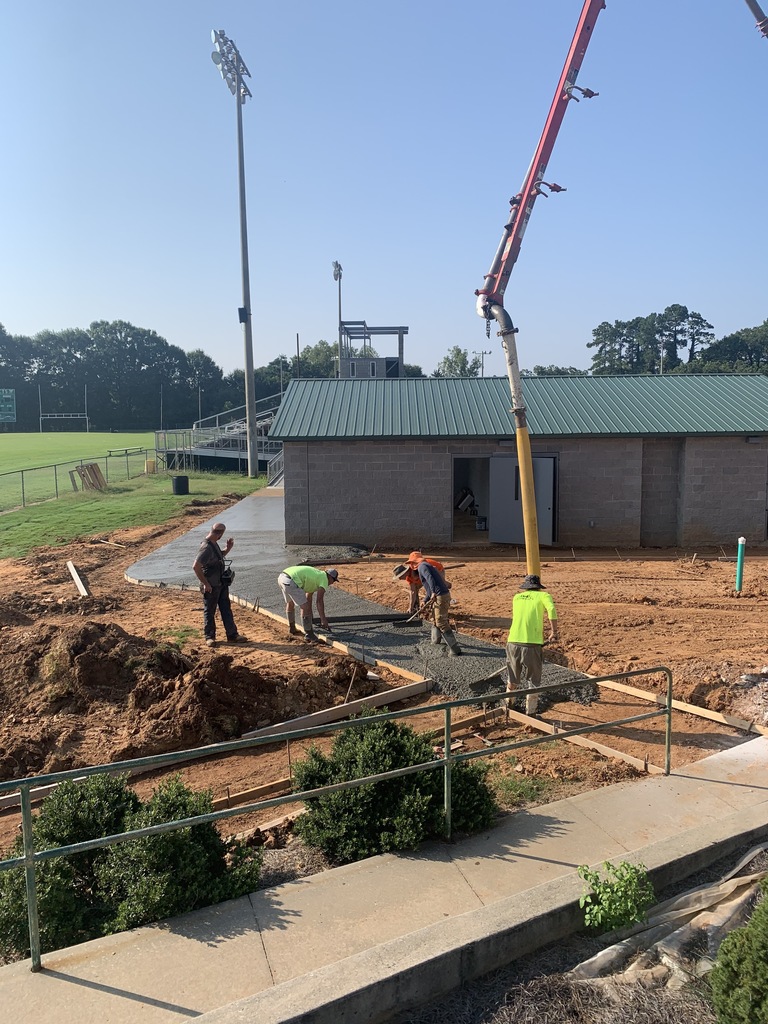Picture showing concession stand and workers pouring concrete side walks. 