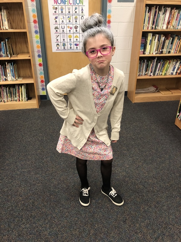 Student dressed up as older adult with glasses and a frown face.
