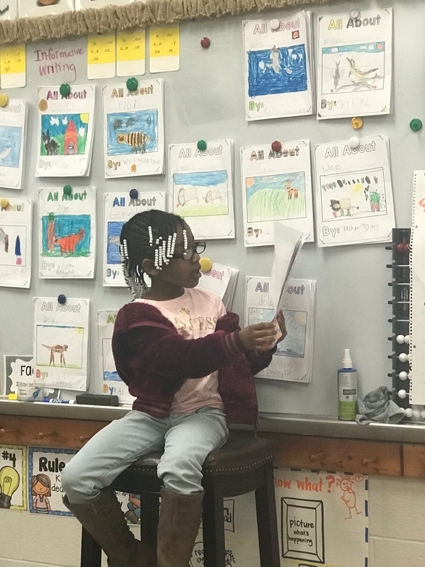 student reads book to class about animal